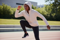 Femme africaine portant la veste Nike beige avec capuche pendant une séance de sport