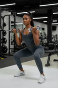 Femme africaine à la salle de sport portant le legging Nike gris foncé avec swoosh blanc
