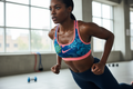 Femme africaine portant la brassière Nike à motifs floraux bleus et roses pendant une séance de sport