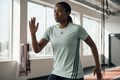 Femme africaine portant le t-shirt Adidas vert menthe avec 3 bandes pendant une séance de sport