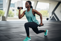 Femme africaine portant le débardeur Nike vert d'eau pendant une séance de sport
